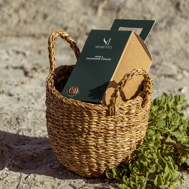 Memento Wine and Champagne Cooler situated in a woven basket on the beach